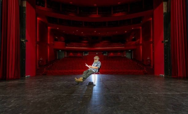 Acteur alleen op een leeg toneel in een rood theater